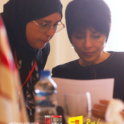 Two participants reviewing meeting documents at the international table.